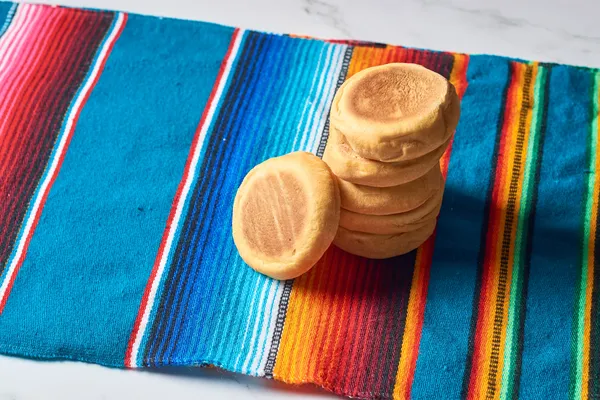 Mexican sweets made from shredded coconut, known as cocadas, displayed at a local market in vibrant colors.