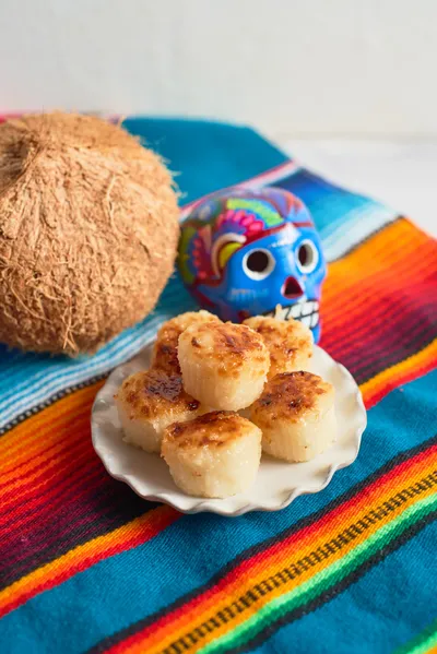 Mexican sweets made from shredded coconut, known as cocadas, displayed at a local market in vibrant colors.